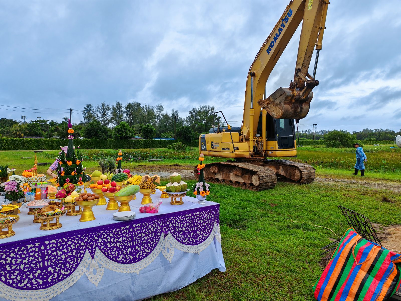Royal Lee Turquoise, Phuket. Photo taken 2025-08-30. Traditional site blessing with offerings; a Komatsu excavator on the cleared land.