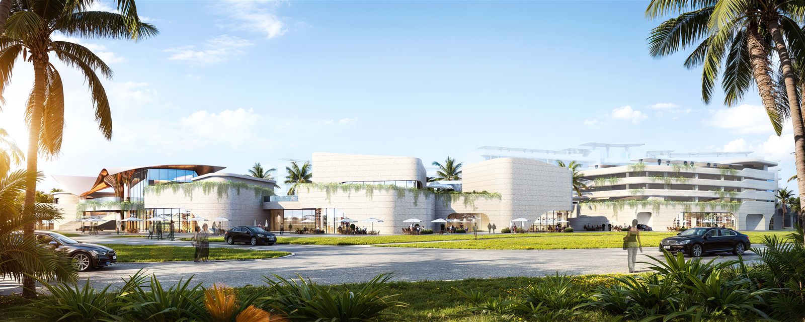 Wide daytime exterior of the open-air mall with tropical stone architecture, planted terraces and street-level shops and cafes